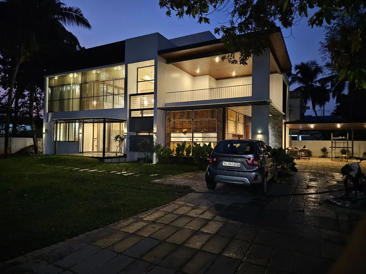 A residence at dusk with internal, façade and canopy lighting circuits live: the visible output of an electrical and automation design.